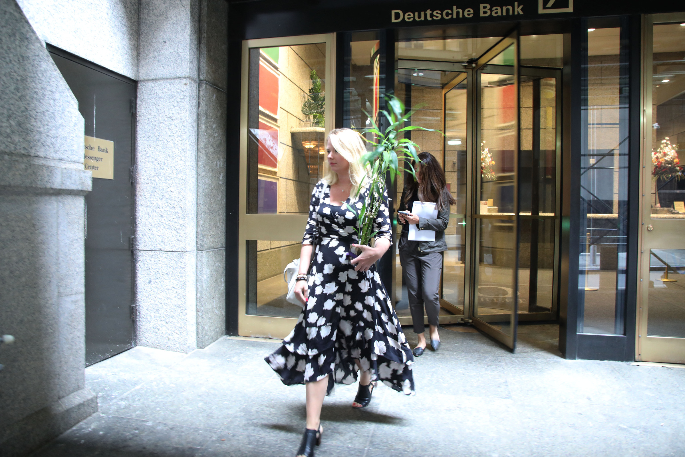Một nhân sự Deutsche Bank tại New York bê chậu cây về khi nghỉ việc trong đợt sa thải năm 2019. Ảnh: AFP